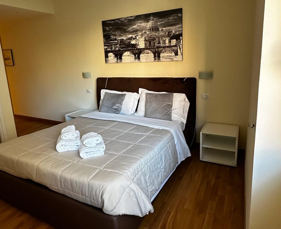 Camera da letto moderna con letto matrimoniale e decorazione murale in bianco e nero.